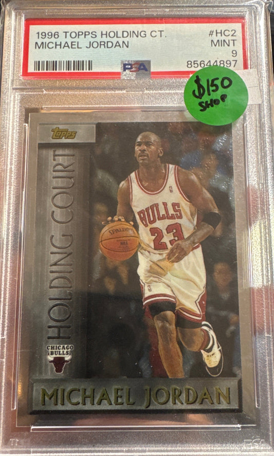Basketball trading card of Michael Jordan held by a person, with a PSA 9 MInt